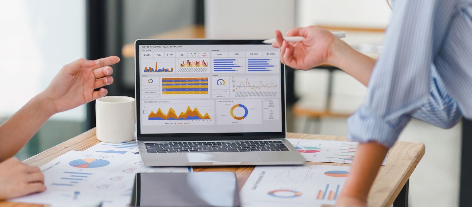 Two data analysts reviewing data analysis dashboard for business strategy on laptop