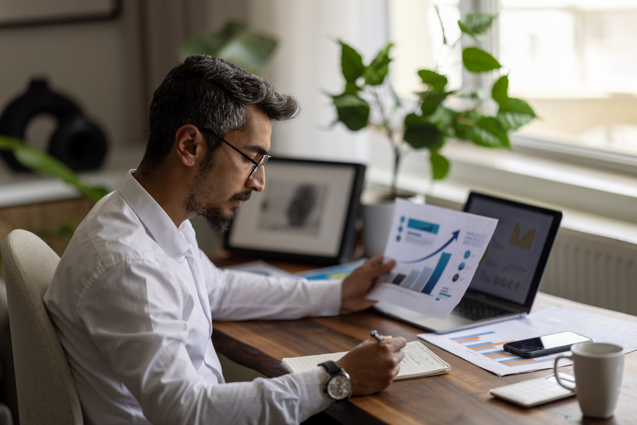 Businessman working on corporate financial report reviewing balance and operations data