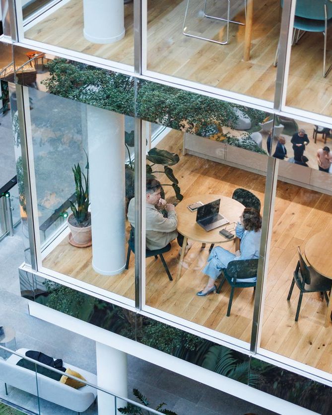 Diverse business executives engage in conversation at modern office cafe seating